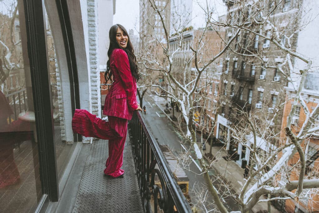 Entrepreneur wearing a bold magenta blazer in front of a city background