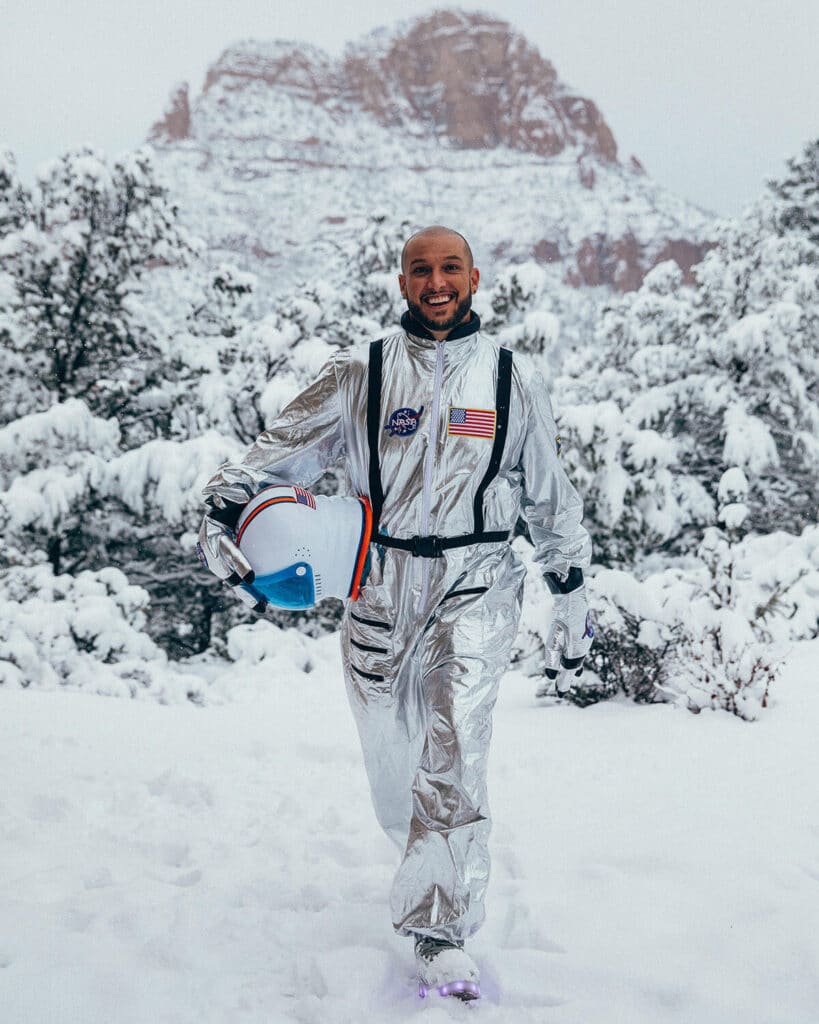 Jaramy Wilson in a silver astronaut suit standing in snowy wilderness — bold, unexpected, visionary