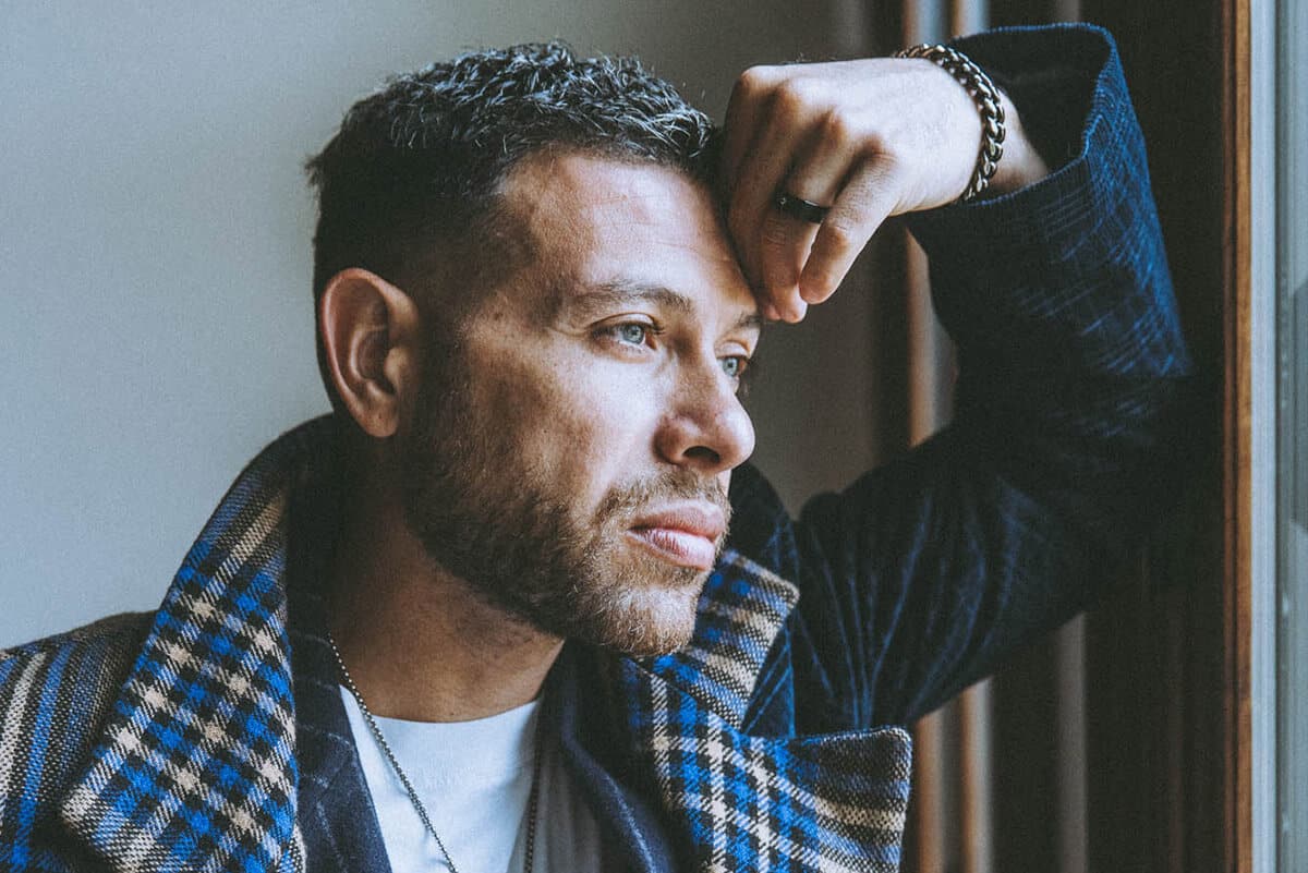 A confident entrepreneur standing in front of a window, captured in elevated, natural editorial light