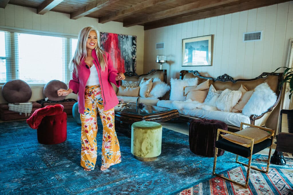 Personal brand client smiling and dancing in a vibrant living room, embodying joyful energy and self-expression after a transformational brand shoot