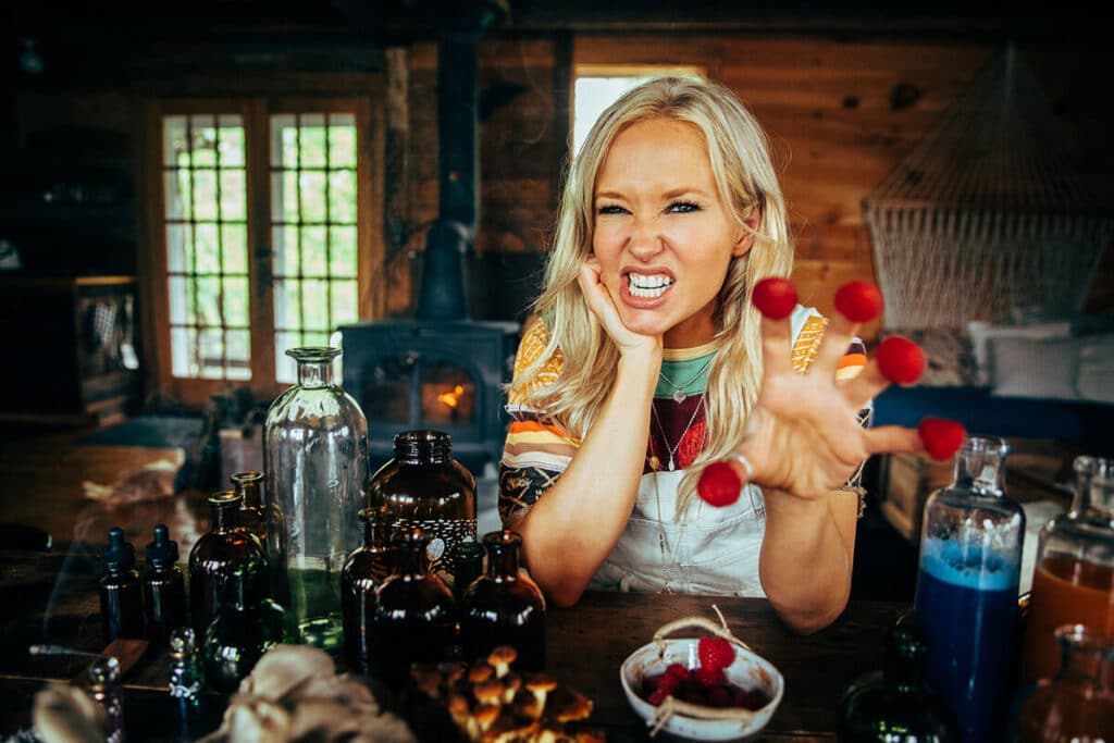 Jenny Sansouci playfully roaring with raspberries on her fingers during a personal brand shoot—capturing liberated expression and joyful authenticity after emotional breakthrough