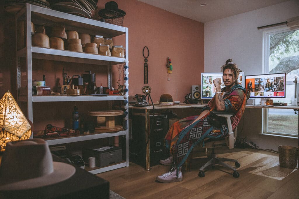 Nick Onken seated in his creative studio surrounded by tools, textures, and visuals that reflect his Elevated Realism™ process.