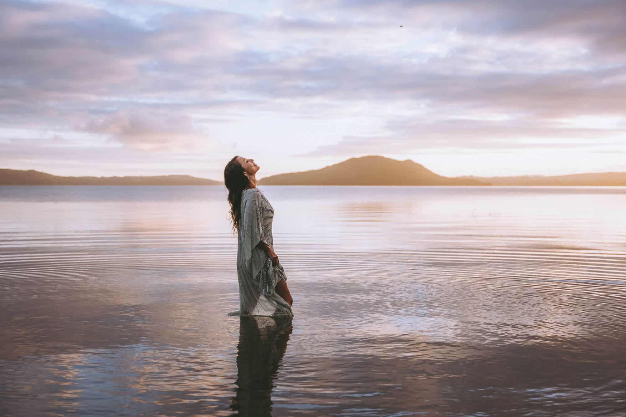 Nicky Clinch standing in nature during her brand shoot, styled in flowing earth tones and captured in soft light