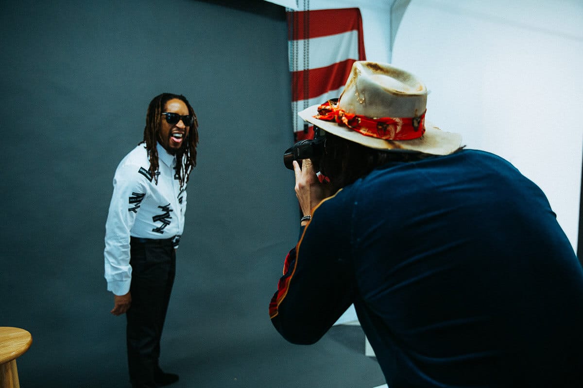 Entrepreneur standing confidently against a bold backdrop during a personal brand shoot, eyes locked on camera with presence