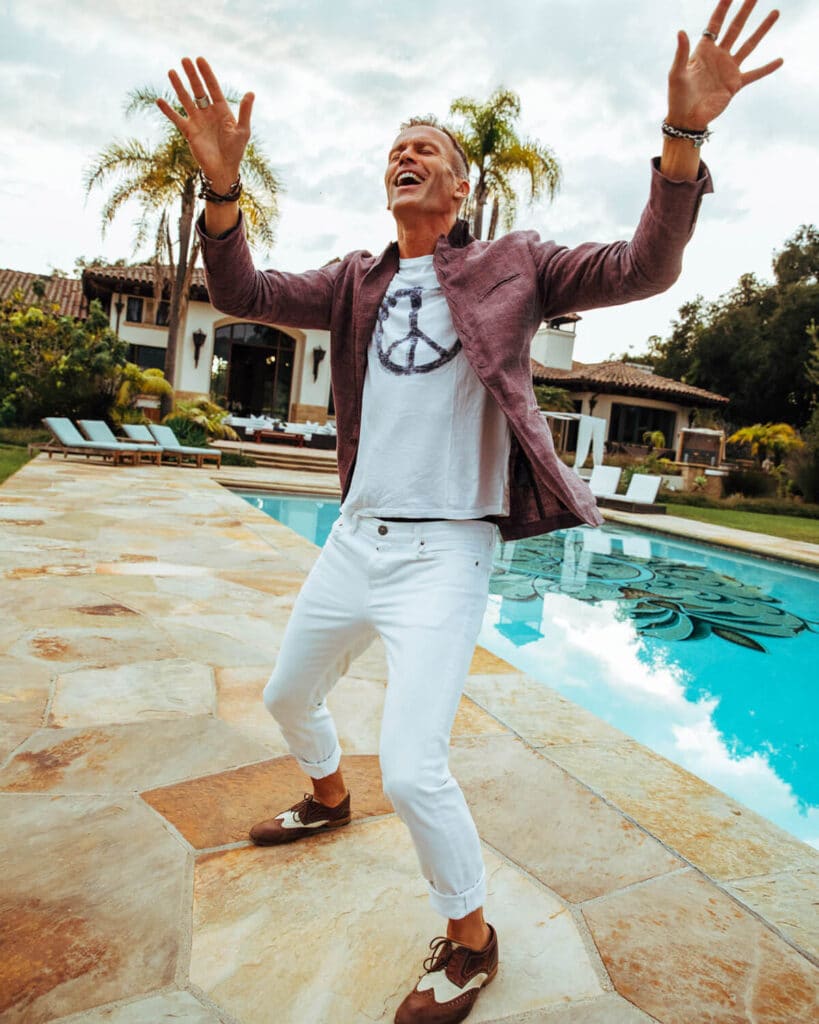 Peter Crone laughing with arms raised during a personal brand photoshoot—capturing emotional range, authentic joy, and the approachable side of embodied leadership