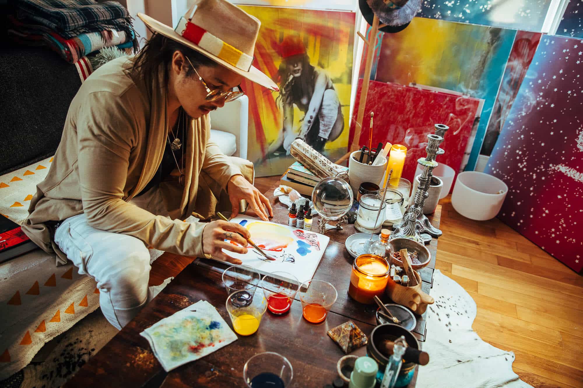 Creative entrepreneur enjoying morning sunlight through a large studio window, surrounded by curated objects that reflect a creative lifestyle