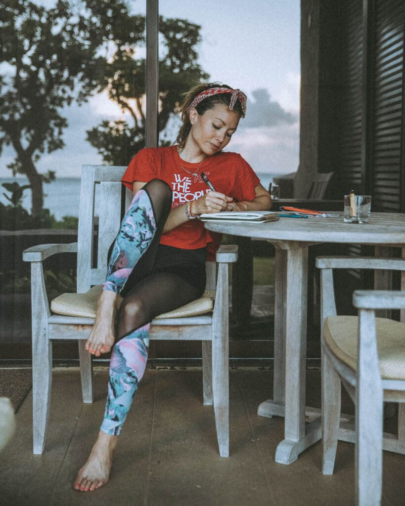 Client relaxing with tea and a journal before shoot day, practicing pre-shoot rituals to prepare energy
