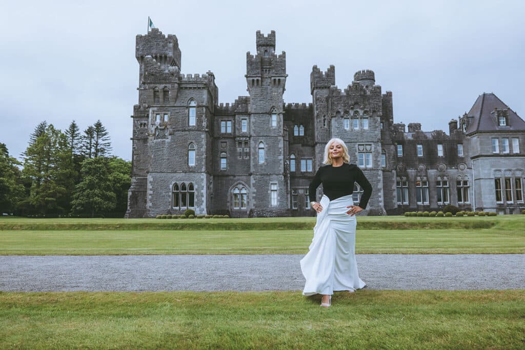 Caoimhe Harrison standing in front of an Irish castle during a personal brand shoot