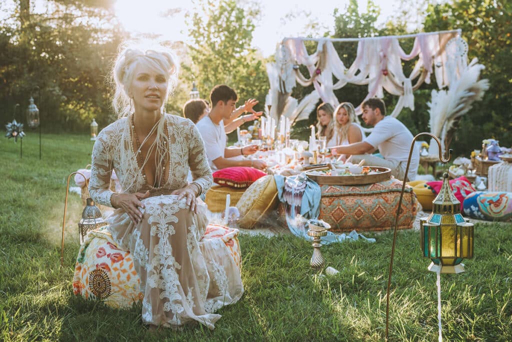 Entrepreneur in a sun-drenched bohemian outdoor space with lush greenery and layered textures