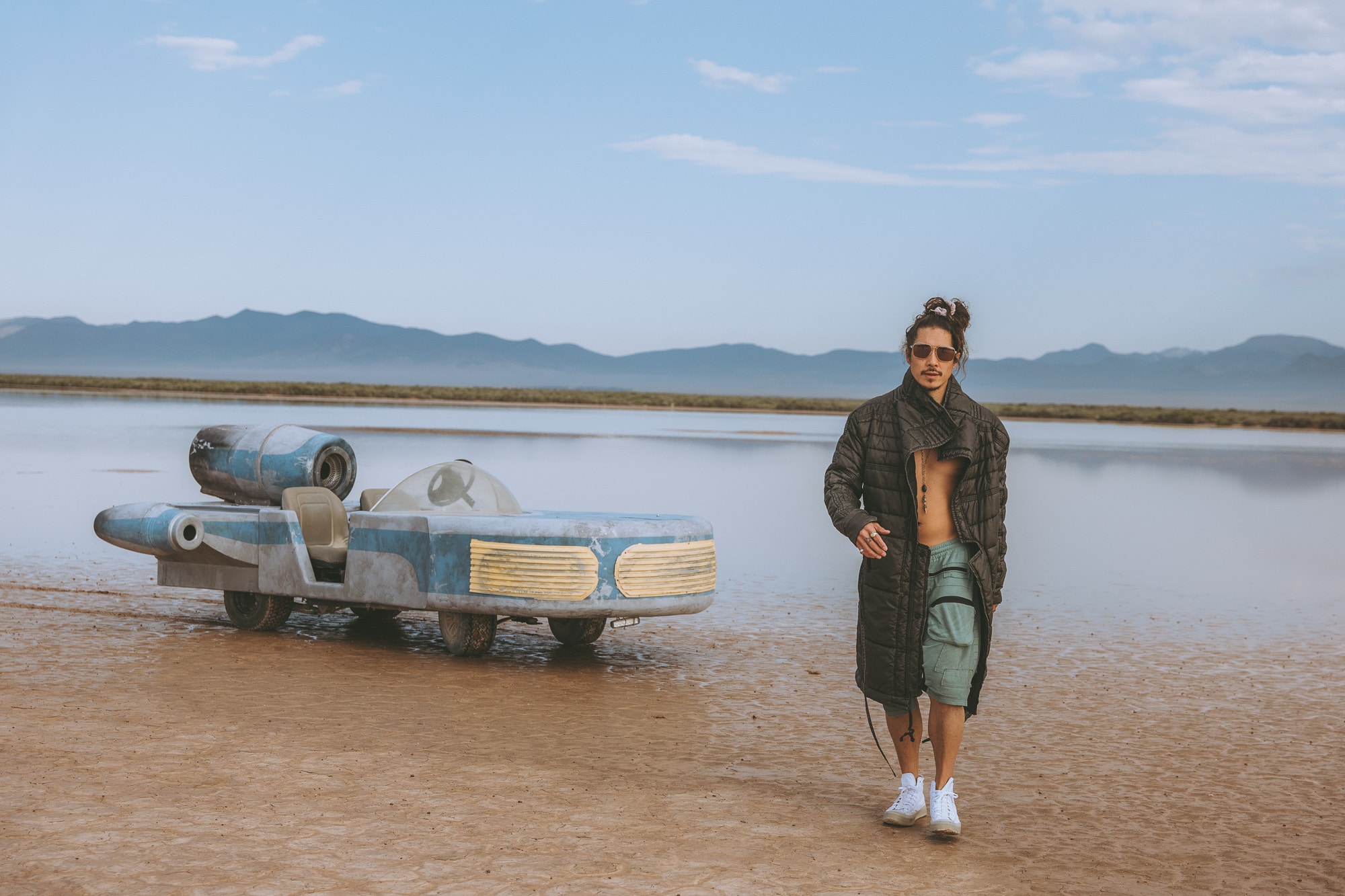 Nick Onken walking across a reflective desert basin near a sci-fi landspeeder, symbolizing visionary pathfinding and creative expansion