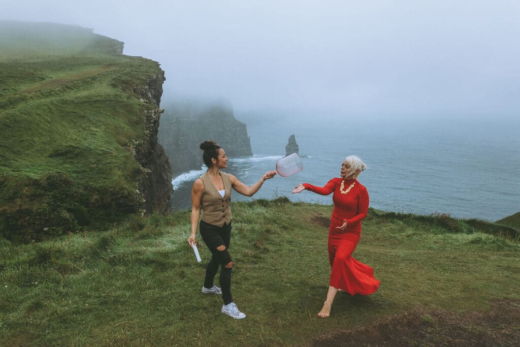 Caoimhe Harrison framed against the vast cliffs of Moher during a storm break, embodying presence and power