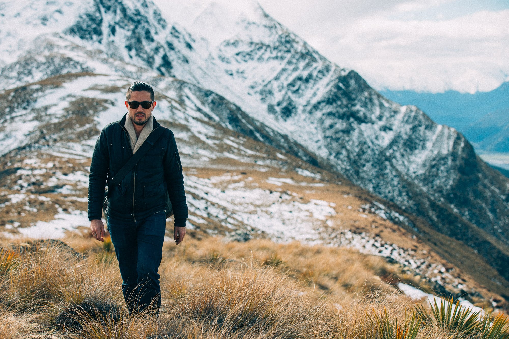 Photographer walking a snow-capped mountain ridge in New Zealand, the long practice of seeing that develops taste